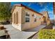 Side view of a tan house with arched windows and a gated side yard at 11220 Robin Park Ave, Las Vegas, NV 89138