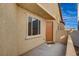 Front door and entryway of a tan house with a small patio at 11220 Robin Park Ave, Las Vegas, NV 89138