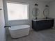 Spa-like bathroom featuring a soaking tub, dual vanities with vessel sinks, dark cabinets, and modern fixtures for a relaxing retreat at 121 Comstock St, Pahrump, NV 89048