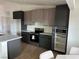 Modern kitchen with stainless steel appliances, stone countertops, custom cabinetry, and adjacent dining area with white chairs at 121 Comstock St, Pahrump, NV 89048