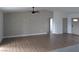 Bright, open-concept living area with wood-look flooring, modern ceiling fan, and wallpaper accent wall creates a cozy, inviting space at 121 Comstock St, Pahrump, NV 89048