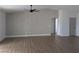Open-concept living area with modern ceiling fan, stylish wallpaper feature wall, and wood-look flooring throughout at 121 Comstock St, Pahrump, NV 89048
