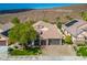 Aerial view of a home with a three-car garage, desert landscaping, and solar panels at 2012 Poetry Ave, Henderson, NV 89052