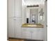 Bathroom with granite countertop, white cabinets, and a large mirror at 2012 Poetry Ave, Henderson, NV 89052