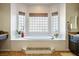 Bright bathroom with a luxurious bathtub, tile flooring, and multiple windows for natural light at 2012 Poetry Ave, Henderson, NV 89052