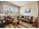 Sitting room with wood laminate flooring, large windows, leather sofa and accent chair at 2012 Poetry Ave, Henderson, NV 89052