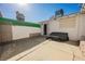 Enclosed backyard featuring a concrete patio, white privacy wall, and door to house at 271 Greenbriar Townhouse Way, Las Vegas, NV 89121