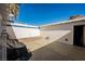 Enclosed backyard featuring a concrete patio, white privacy wall, and door to house at 271 Greenbriar Townhouse Way, Las Vegas, NV 89121