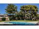 Community pool surrounded by mature trees and lush green lawns, offering a relaxing retreat at 271 Greenbriar Townhouse Way, Las Vegas, NV 89121