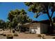 Street view of a charming single-story house with mature trees and desert landscaping at 271 Greenbriar Townhouse Way, Las Vegas, NV 89121