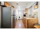 Eat-in kitchen includes gray refrigerator, wood cabinets, wood floors, and stainless steel sink at 271 Greenbriar Townhouse Way, Las Vegas, NV 89121