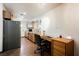 Eat-in kitchen includes gray refrigerator, wood cabinets, wood floors, and a built in desk at 271 Greenbriar Townhouse Way, Las Vegas, NV 89121