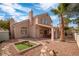 Landscaped backyard with patio, stone pathway and palm trees at 2928 Cape Verde Ln, Las Vegas, NV 89128