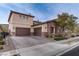 Two-story house with stone and stucco exterior, brown garage doors, and landscaped yard at 37 Carolina Cherry Dr, Las Vegas, NV 89141