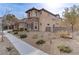 Two-story house with stone and stucco exterior, brown garage doors, and landscaped yard at 37 Carolina Cherry Dr, Las Vegas, NV 89141