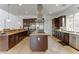 Modern kitchen with dark wood cabinetry, granite countertops, and stainless steel appliances at 37 Carolina Cherry Dr, Las Vegas, NV 89141