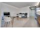 Open-concept living area with contemporary furnishings, a glass dining table and sleek kitchenette at 3722 Las Vegas Blvd # 305, Las Vegas, NV 89158