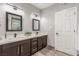 Bathroom featuring double sink vanity, dark cabinets, quartz countertop, and modern light fixtures at 4410 E Boston Ave, Las Vegas, NV 89104