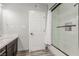 Bathroom featuring a combination shower and tub with white tiling, a glass door, and chrome hardware at 4410 E Boston Ave, Las Vegas, NV 89104