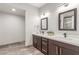 Bathroom with double vanity, dark cabinets, quartz countertop, and decorative plant on the counter at 4410 E Boston Ave, Las Vegas, NV 89104