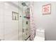 Corner view of a white tiled combination shower and tub with glass doors and a white toilet at 4410 E Boston Ave, Las Vegas, NV 89104