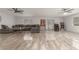 Spacious living room with gray flooring, two ceiling fans, a large gray sectional, and three windows at 4410 E Boston Ave, Las Vegas, NV 89104
