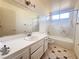 Clean bathroom with a bathtub, single sink vanity and tiled floor at 4684 Trevins Ave, Las Vegas, NV 89103