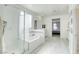 Bright bathroom featuring a tub with a textured glass door and wood-style floors at 4801 Westmont Dr, Pahrump, NV 89061