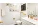 A powder room featuring white sink and toilet with gold fixtures and decor at 4801 Westmont Dr, Pahrump, NV 89061