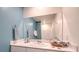 Modern bathroom with white vanity, blue walls, and a large mirror at 6193 Aster Garden St # 146, North Las Vegas, NV 89081