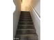 Carpeted staircase with white handrail provides access to the upper level of the home at 6225 Dan Blocker Ave # 102, Henderson, NV 89011