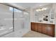 Bright bathroom features a glass-enclosed shower, double vanity with modern fixtures, and neutral tiling at 8719 Rio Andir Ave, Las Vegas, NV 89148