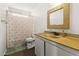 Neutral bathroom with a patterned shower curtain, golden sink, and matching framed mirror at 204 Cimarron Ct, Henderson, NV 89002