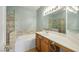 Updated bathroom with double sink vanity, shower over tub, and marble tile surround at 2050 W Warm Springs Rd # 3322, Henderson, NV 89014