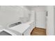 Neat laundry room featuring white cabinets, utility sink, washer, dryer, and hardwood floors at 2050 W Warm Springs Rd # 3322, Henderson, NV 89014