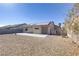 Spacious backyard featuring gravel landscaping, a concrete patio, and a house equipped with solar panels at 2220 Patriotic Ln, North Las Vegas, NV 89032