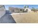 Expansive backyard with low-maintenance gravel, a concrete patio, and a view of the home's exterior at 2220 Patriotic Ln, North Las Vegas, NV 89032