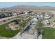 Aerial view of a community with a playground, pool, and palm trees, set against a mountain backdrop at 2681 Tuxedo Black Ct, North Las Vegas, NV 89086