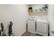 Functional laundry room with modern washer and dryer units and storage shelves at 2681 Tuxedo Black Ct, North Las Vegas, NV 89086