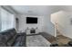 Cozy living room features a plush sofa, a large TV, and access to the staircase at 2681 Tuxedo Black Ct, North Las Vegas, NV 89086