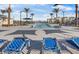 Luxurious pool area with modern lounge chairs, palm trees, and inviting blue waters for relaxation at 2681 Tuxedo Black Ct, North Las Vegas, NV 89086