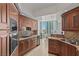 Gourmet kitchen featuring granite counters, wood cabinets, and stainless steel appliances with a dining space at 2777 Paradise Rd # 1105, Las Vegas, NV 89109
