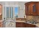 Gourmet kitchen featuring granite counters, wood cabinets, and breakfast nook with floor-to-ceiling window views at 2777 Paradise Rd # 1105, Las Vegas, NV 89109