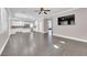 Open living room with hardwood floors, kitchen and large TV at 2891 Painted Lilly Dr, Las Vegas, NV 89135