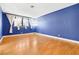 Spacious bedroom with hardwood floors and blue walls at 3360 Paso Andres St, Las Vegas, NV 89146