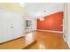 Living room with hardwood floors and an orange accent wall at 3360 Paso Andres St, Las Vegas, NV 89146