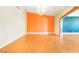 Living room with hardwood floors and an orange accent wall at 3360 Paso Andres St, Las Vegas, NV 89146