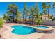 Relaxing kidney shaped pool and spa surrounded by trees at 3360 Paso Andres St, Las Vegas, NV 89146