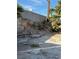Backyard featuring a retaining wall, desert landscaping, and debris at 3551 Rio Mayo Dr, Las Vegas, NV 89121