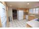 Bright kitchen features wood cabinets, tile flooring, white appliances, and shutters over the sink at 3905 E Cherokee Ave, Las Vegas, NV 89121